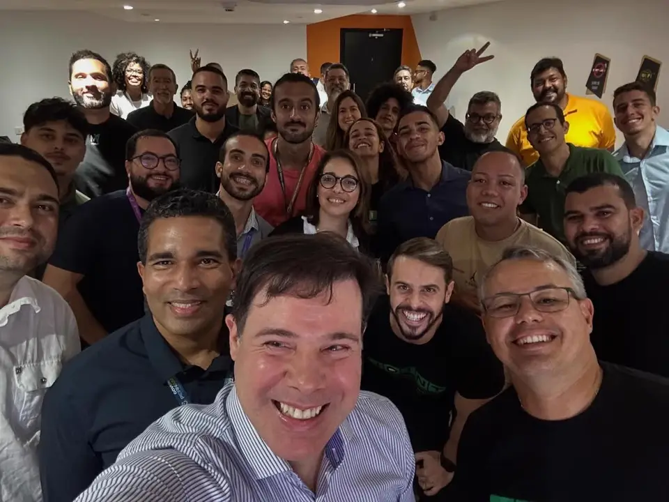 Cesar Andrade e participantes da JoInT+ posam sorridentes para selfie coletiva no auditório do ITBC Softex.