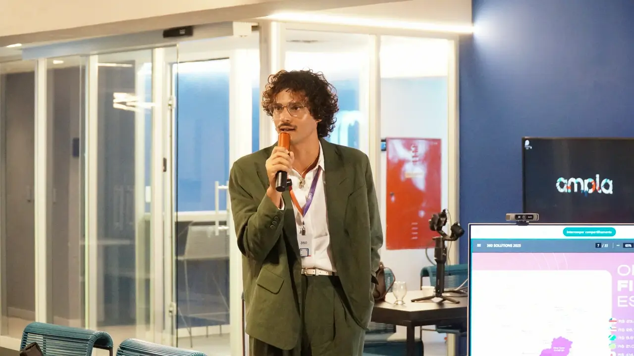 Elevelto Alves da 360 Consultoria fala ao microfone em evento corporativo da Joint, com telão da Ampla ao fundo.